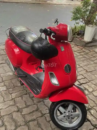 Красный скутер Piaggio Vespa