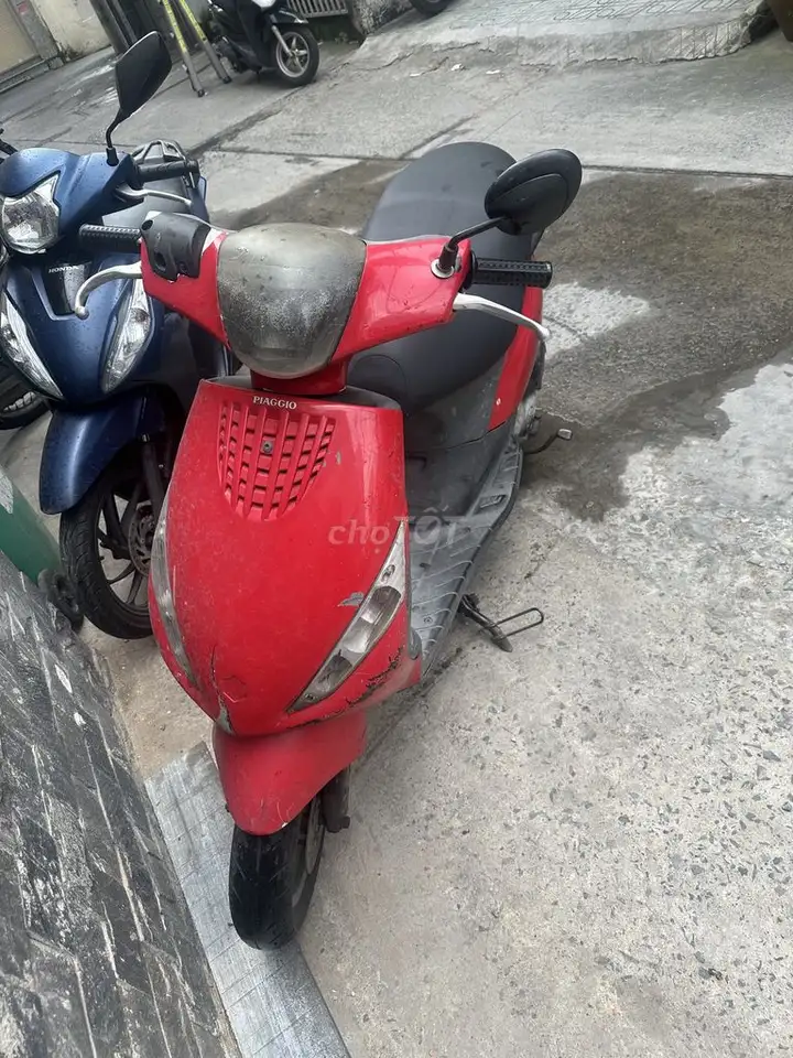 Женский красный скутер Piaggio Vespa